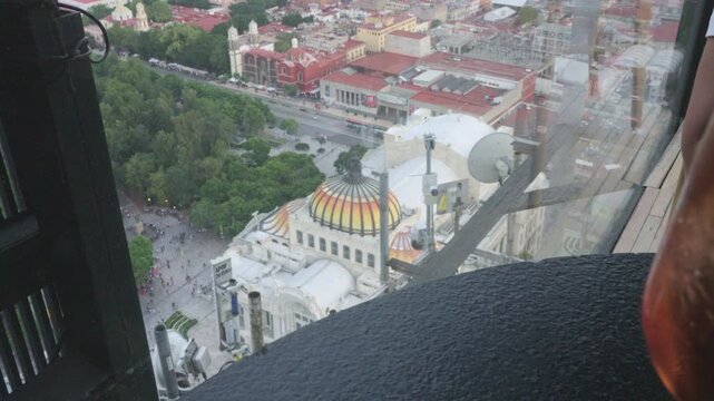 Woman drinking an iced aperitif with a stunning panoramic view of mexico city and bellas artes