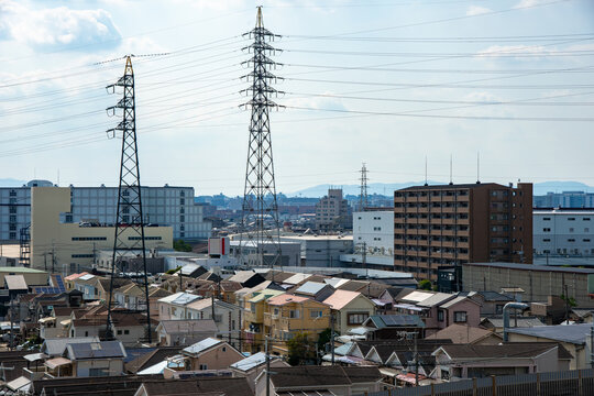 住宅街と送電鉄塔が広がる都市近郊の風景