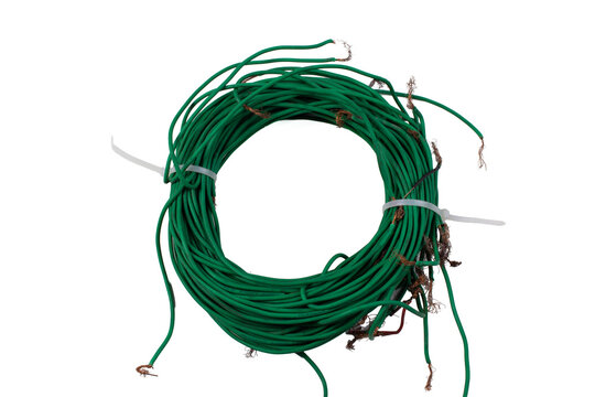 Coiled green electrical wire cable with copper conductor isolated on white background. Wiring, electronics and construction concept.