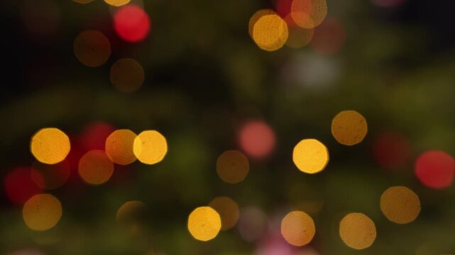 Blurry christmas tree lights glowing with a warm and magical festive bokeh effect creating a beautiful and dreamy winter holidays abstract background celebrating the holiday season