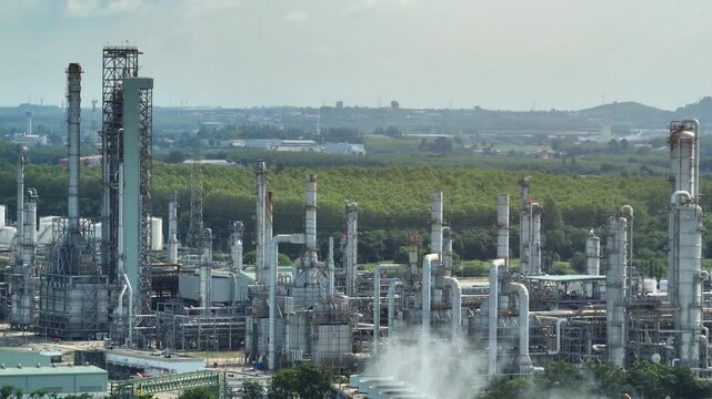 Aerial industrial landscape featuring cooling towers, treatment facilities, and green buffer zones, illustrating eco-industrial park design, water recycling, and sustainable operations. 4k.
