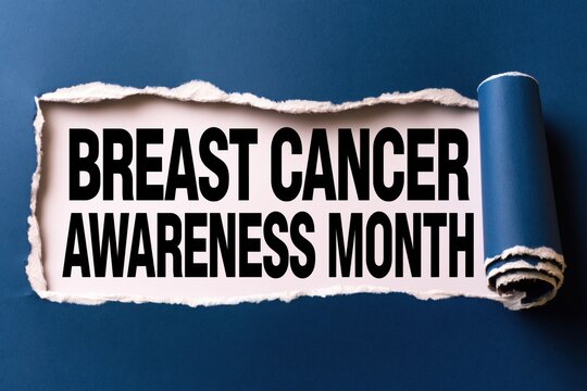 Black text breast cancer awareness month written under torn blue paper