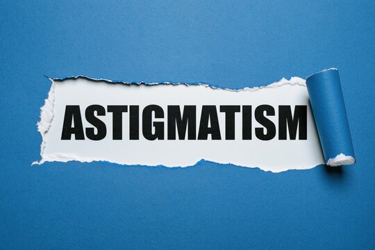 Black text astigmatism written under torn blue paper