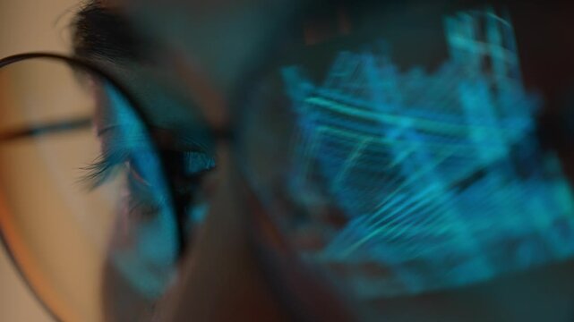 A construction engineer wearing eyeglasses examines a digital building construction model on a futuristic display, symbolizing structural design, BIM technology, project planning, and engineering.
