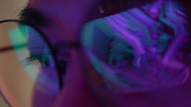 An electronics engineer wearing eyeglasses examines a digital circuit board interface, symbolizing semiconductor technology, electronic design, precision engineering, and advanced innovation. 4k.
