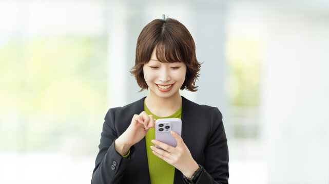 スマートフォンを使う笑顔のビジネスウーマン, Smiling Businesswoman Using a Smartphone