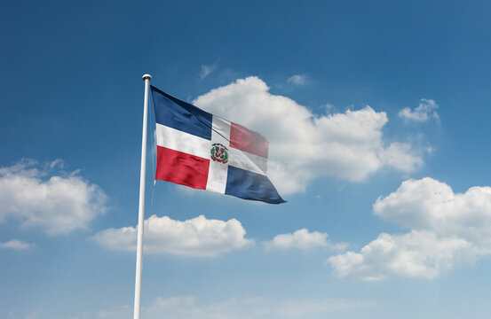 Dominican Republic flag waving in beautiful sky.