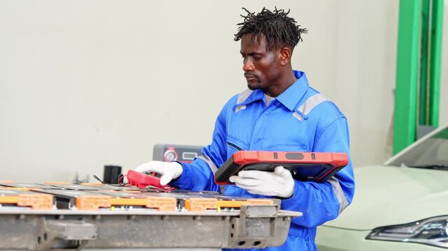 Experienced technician performing automotive diagnostics using various tools in a well equipped workshop setting