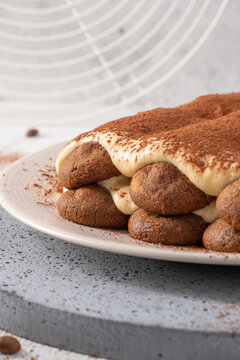 Macro close up of a traditional Italian tiramisu dessert dusted with cocoa powder