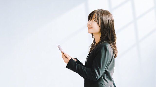 スマートフォンを使う笑顔の女性・ビジネスウーマン