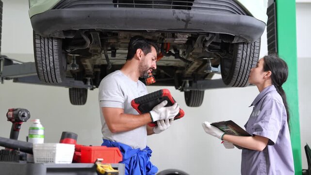 Team of mechanics working together in an auto repair shop demonstrating effective collaboration and problem solving skills