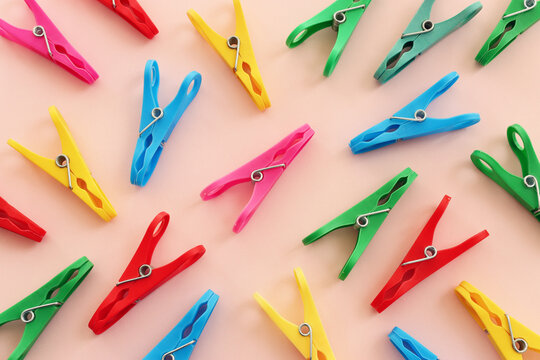on pink background. Top view pattern clothespins