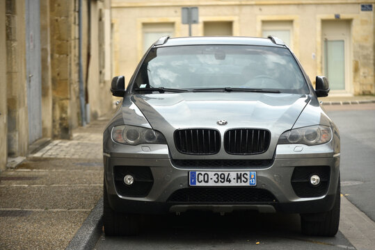 St - Amand Montrond - France - 3 august 2026 - Front view of a gray BMW X5 E70 luxury SUV parked on a quiet village street 
