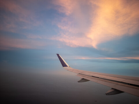 Fleksibel flight wing soaring through automatic sunset clouds in soft sky