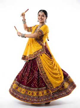 Young woman dancing garba with dandiya sticks, isolated on white background