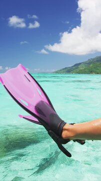 Snorkel fun legs funny snorkeling fins over water at travel luxury vacation. Snorkeler relaxing on overwater villa deck at resort holiday. Raw unedited vertical video of real woman model.