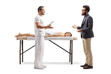 Obraz premium Male massage therapist talking to a man next to a female client