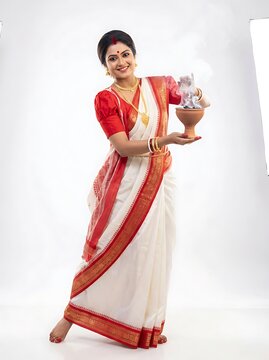 Bengali woman in traditional white and red saree performing dhunuchi dance