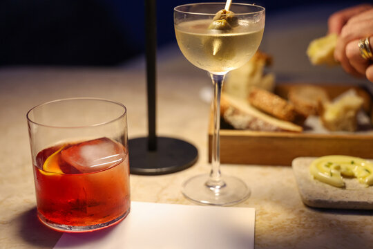 Two cocktails and fresh bread sit on a marble table in Greece, capturing the refined atmosphere of Mediterranean dining and evening leisure.