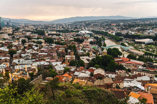 Aerial view of Old Tbilisi cityscape with Bridge of Peace and Mtkvari River at sunset, Tbilisi, Georgi