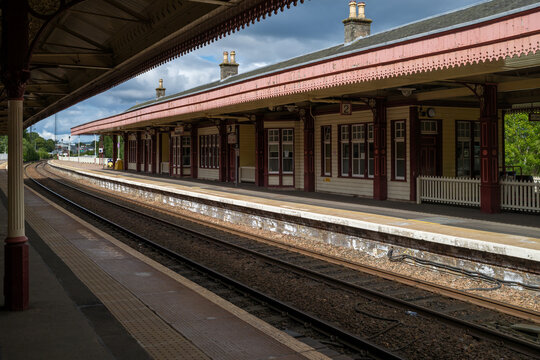 Empty platforms at Aviemore&rsquo;s Victorian railway station under a clear summer sky, awaiting trains from the north