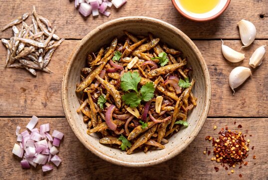 Kenyan Fried Omena Small Dried Fish with Garlic and Onions on Wooden Background