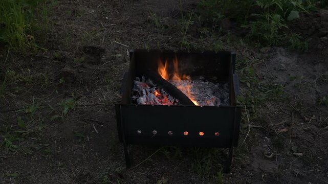 timelapse of fire flaring up and coals forming in a barbecue grill outdoors