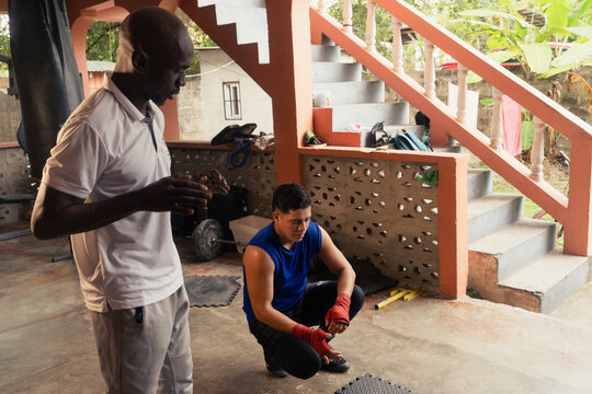 Coach teaching boxing technique to young athlete