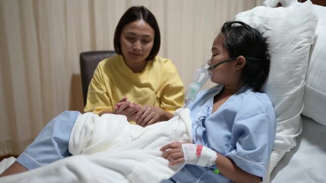 A concerned mother holds her sick child's hand while the child receives oxygen therapy in a hospital bed. Family support, pediatric healthcare, compassion, medical treatment, and hope for recovery.