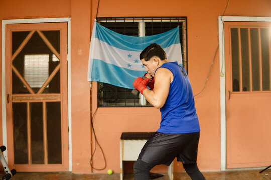 Young boxer training with hand weights for fitness