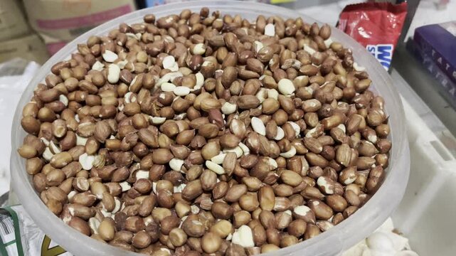 Raw peanuts with skin piled up in a bowl
