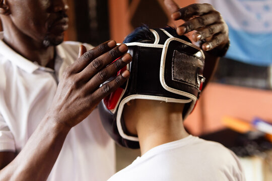 Adult helping young person preparing for boxing training