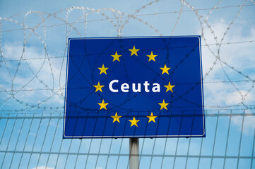 Obraz premium Ceuta border crossing, illegal immegration and migration to EU, barbed wire, refugee invasion, fence coils of razor wires, protection and security concept