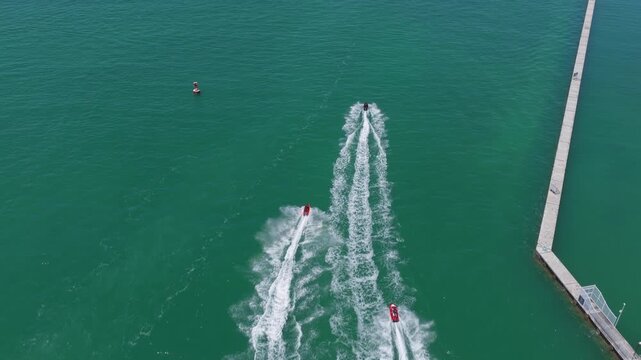 Aerial top view at vacation. Jet ski in motion. Summer vacation activity. Water sport activity in summer. Sea beach lifestyle. Beach life concept. Vacation on summer