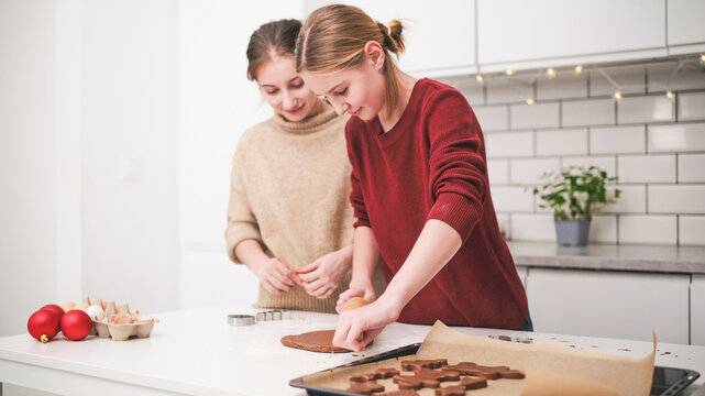 Sisters Joyfully Roll Out Gingerbread Dough, Baking Cookies For A Festive Christmas Celebration