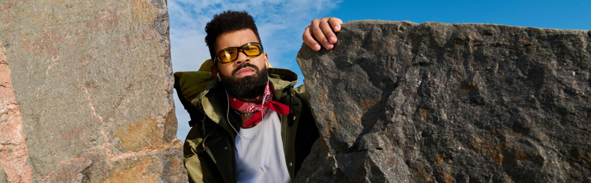 Handsome hiker explores rugged mountain terrain under a bright sky