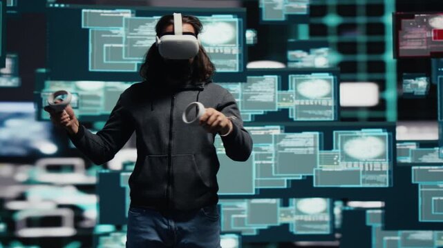 Male cyber spy wears virtual reality glasses while programming a data breach, bypassing network security for identity theft, covert intrusion and digital infiltration.