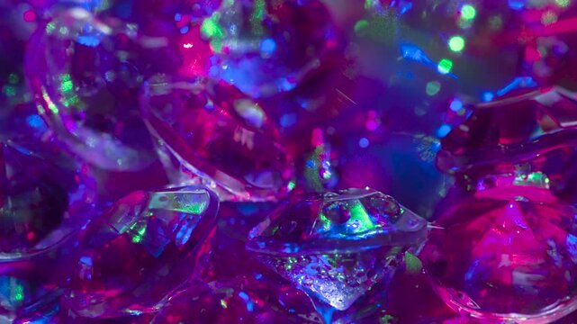 Sparkling Diamond Facets in Laser Light. Small crystals with a classic cut on a mirror surface slowly move in front of the camera, shimmering in the laser beams
