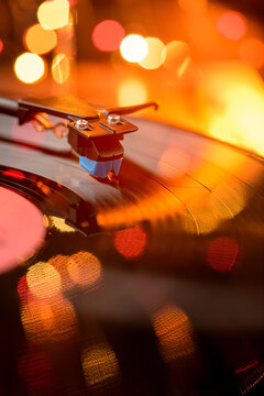 Turntable playing vinyl record with warm bokeh lights