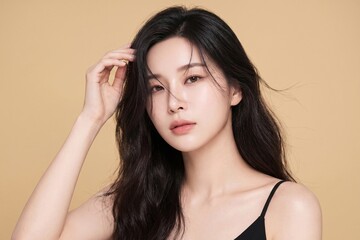 Naklejka premium Refined beauty portrait of a young woman with smooth radiant skin, luminous complexion, natural makeup, and elegant styling, ideal for luxury skincare, serums, and cosmetics advertising