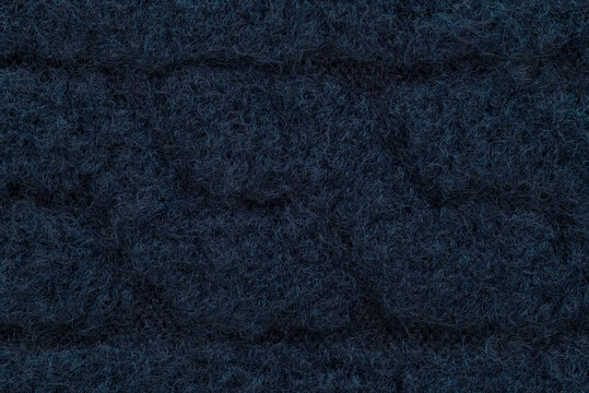 Extreme close up macro shot of navy blue wool fabric revealing the fine felted fibers and subtle texture of the knit weave.