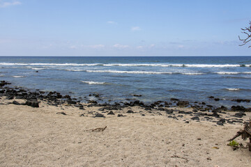 Ocean waves washing over black volcanic stones on a sandy beach at the Big Island Hawaii © Joao Vieira