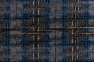 Flat lay of a grey wool fabric with a blue and tan tartan check overlay, well suited for menswear,...