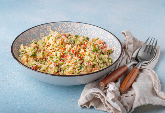 Tabbouleh salad couscous vegetables bowl Middle Eastern blue background