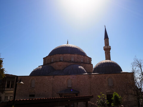 Mosque with domes and minaret against a clear blue sky