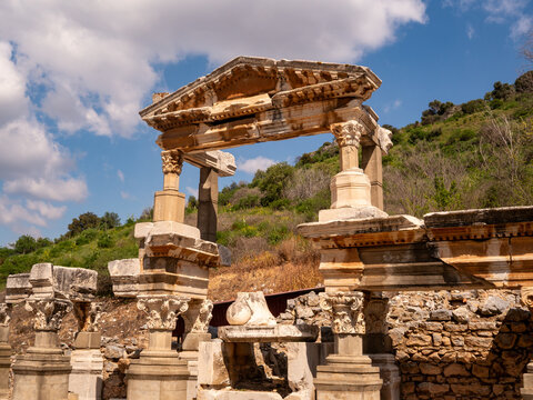 Ancient stone archway ruins against a blue sky.
