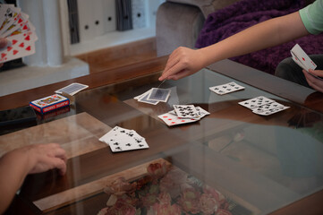 Teenage boy drawing a card during a family card game at home © C&A
