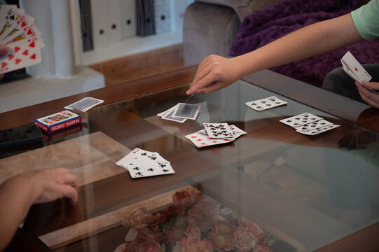Teenage boy drawing a card during a family card game at home