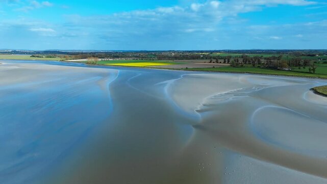 Normandy tidal bay landscape with open sand flats, gentle curves of water and a clean minimalist coastal composition