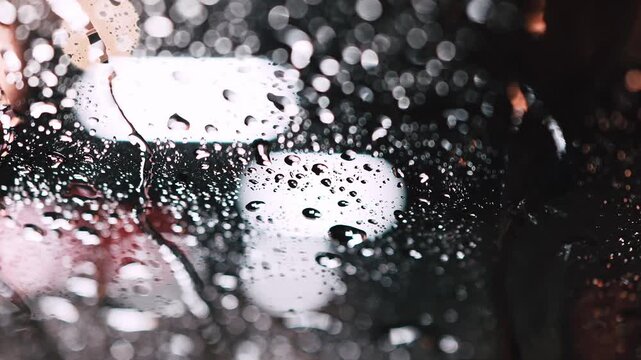 雨に濡れたガラス表面を伝う水滴のクローズアップ